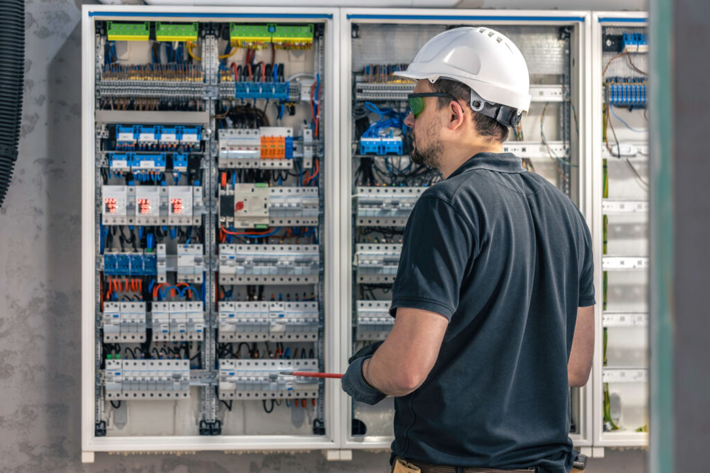 a-male-electrician-works-in-a-switchboard-using-an-2024-03-21-15-16-06-utc2.jpg